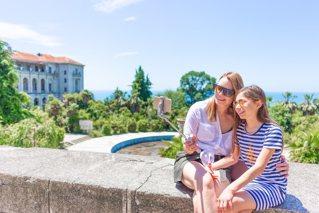 Gelukkige familie moeder en haar schattige dochtertje op zomervakantie nemen selfie met smartphone