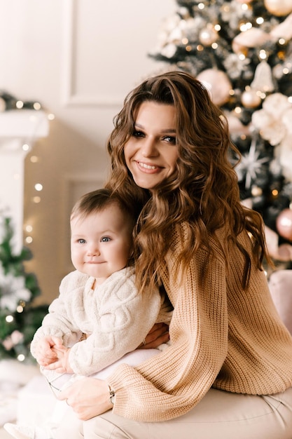 Gelukkige familie moeder en kind dochter op kerstochtend bij de kerstboom met geschenken