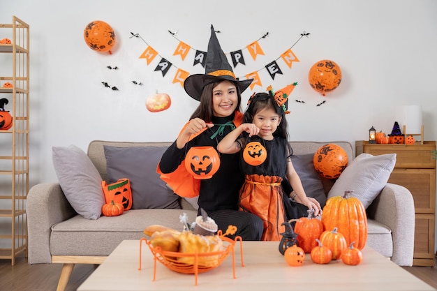 Gelukkige familie moeder en kind gelukkig meisje met Halloween thuis samen prachtig versierd
