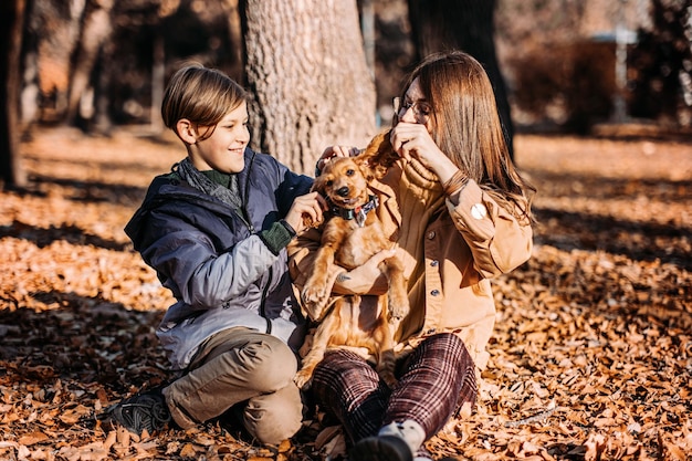 Gelukkige familie moeder en tiener jongen zoon plezier met cocker spaniel puppy in herfst park