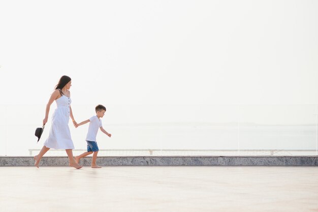 Gelukkige familie moeder en zoon op het strand aan zee in de zomer