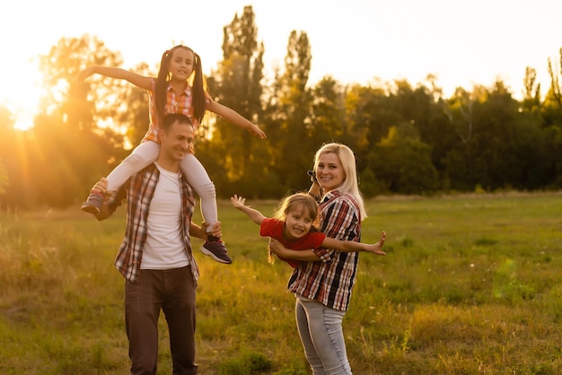 Gelukkige familie: moeder vader en kind dochter op natuur op zonsondergang