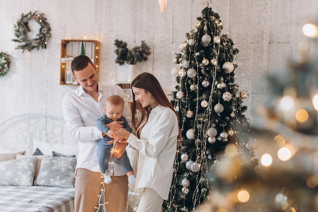 gelukkige familie moeder, vader en kind. kerstboom