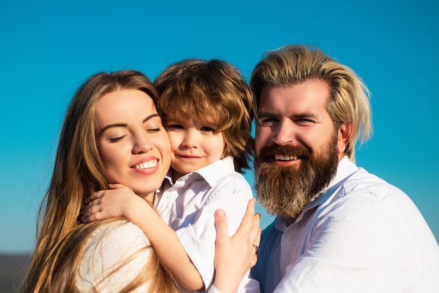 Gelukkige familie, moeder, vader en kinderen zoon omarmen. Jonge glimlachende familie met één kind dat samen plezier heeft. Kinderen houden van en knuffelen. Lach gezicht.