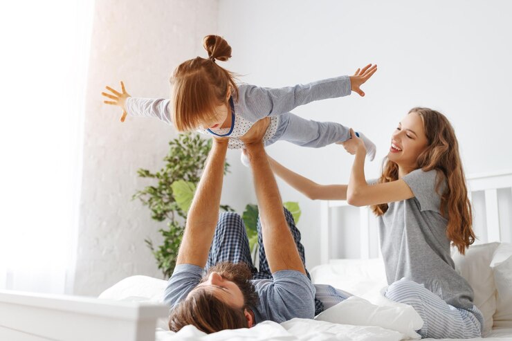 Foto gelukkige familie moeder vader en vader kind dochter in bed