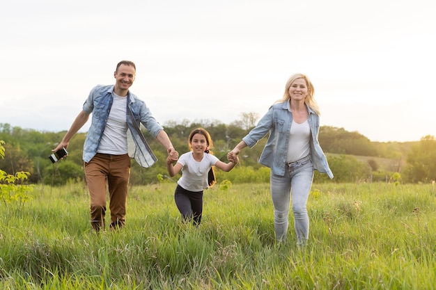 Gelukkige familie: moeder, vader, kind dochter op de natuur op zonsondergang.