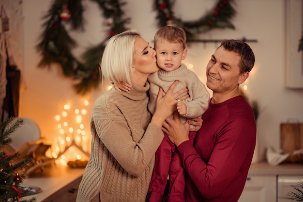 Gelukkige familie moeder vader zoon bereiden zich voor op het nieuwe jaar thuis in de keuken.