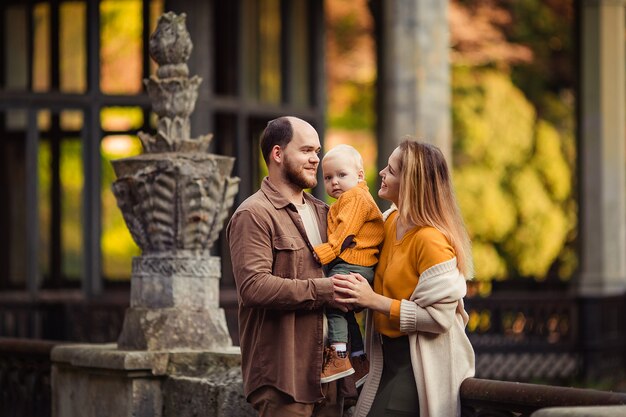 Gelukkige familie op een wandeling in de herfst tegen de achtergrond van een verlaten treinstation in Abchazië.