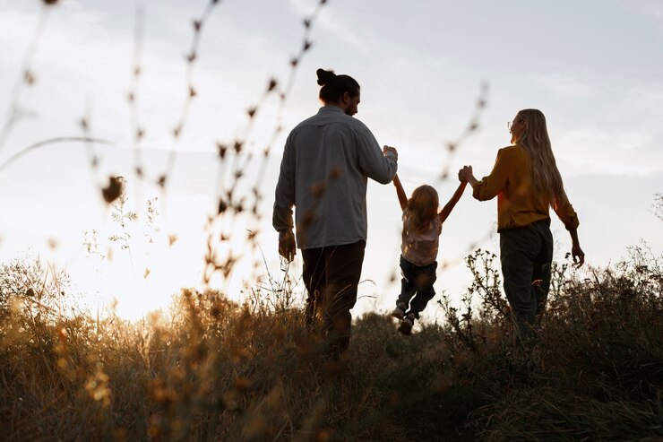 Gelukkige familie op een zonsondergangwandeling in de avond