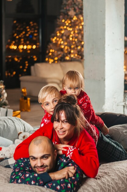 Gelukkige familie op het bed bij de kerstboom