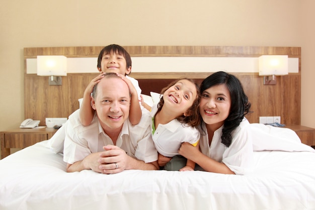 Gelukkige familie op wit bed