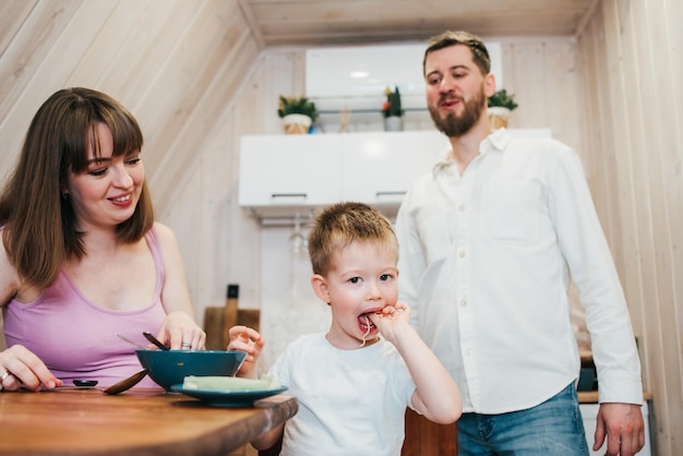 Gelukkige familie pasta eten in de keuken