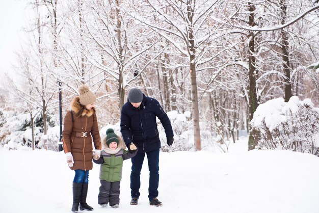 Gelukkige familie plezier en spelen met sneeuw in bos