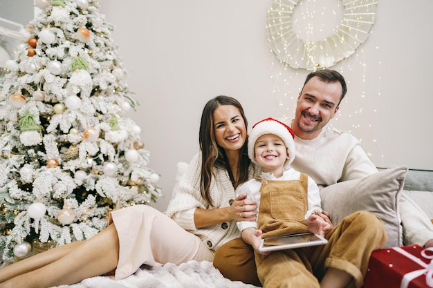 Gelukkige familie plezier op digitale tablet in bed met kerst