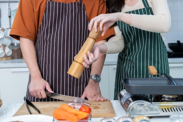 Foto gelukkige familie portret van liefhebbende jonge aziatische van plezier staan een vrolijke bereiden van eten en genieten koken koken met groenten vlees brood terwijl staan op een keuken condo leven of thuis