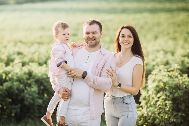 Gelukkige familie poseren op een groen veld