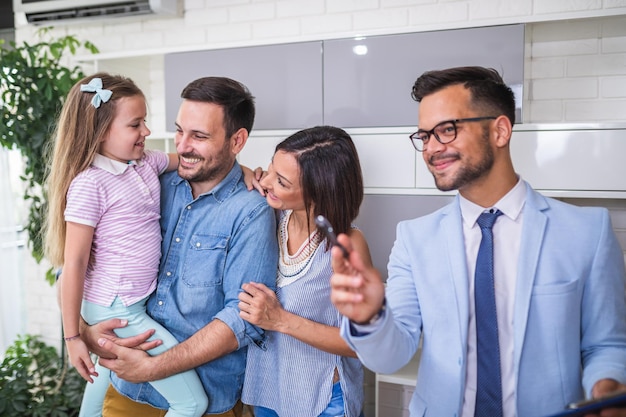 Gelukkige familie praten met makelaar over het kopen van een nieuw huis.