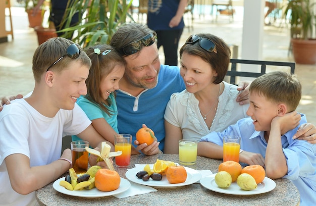 Gelukkige familie samen ontbijten in het buitencafé in het resort