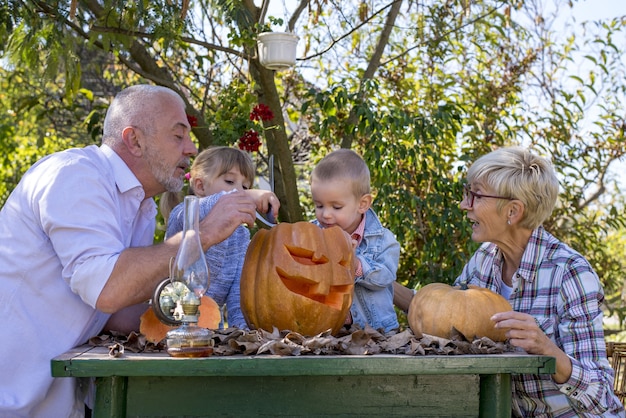 Gelukkige familie samen pompoen snijden en samen genieten van een dag