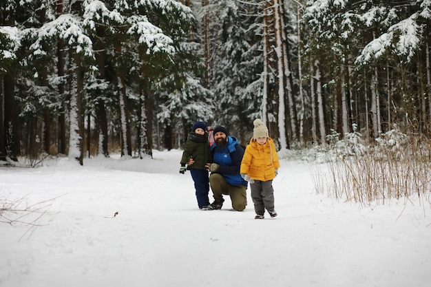 Gelukkige familie spelen en lachen in de winter buiten in de sneeuw. Stadspark winterdag.