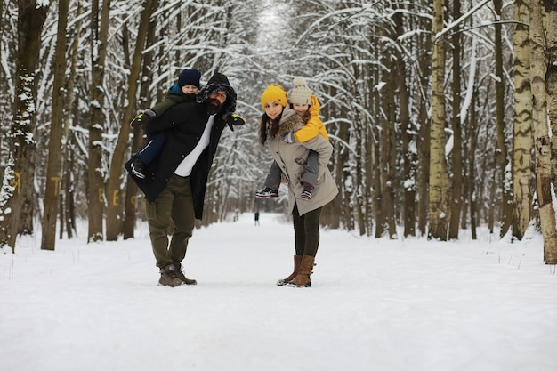 Gelukkige familie spelen en lachen in de winter buiten in de sneeuw. Stadspark winterdag.