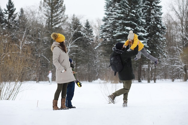 Gelukkige familie spelen en lachen in de winter buiten in de sneeuw. stadspark winterdag.