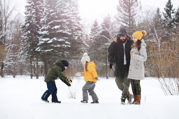 Gelukkige familie spelen en lachen in de winter buiten in de sneeuw. Stadspark winterdag.