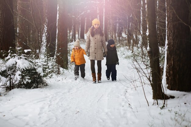 Gelukkige familie spelen en lachen in de winter buiten in de sneeuw. stadspark winterdag.