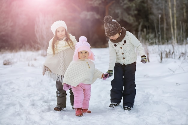 Foto gelukkige familie spelen en lachen in de winter buiten in de sneeuw. stadspark winterdag.