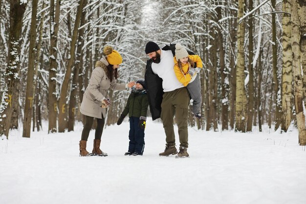 Gelukkige familie spelen en lachen in de winter buiten in de sneeuw. Stadspark winterdag.