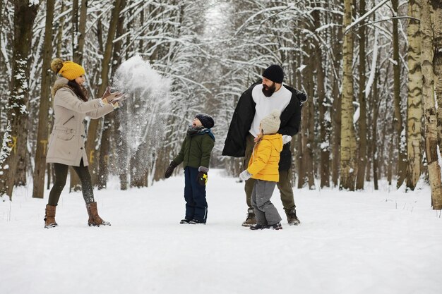 Gelukkige familie spelen en lachen in de winter buiten in de sneeuw. Stadspark winterdag.