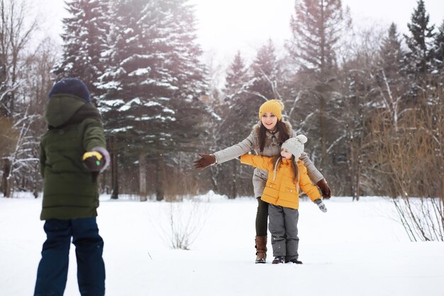 Gelukkige familie spelen en lachen in de winter buiten in de sneeuw. Stadspark winterdag.