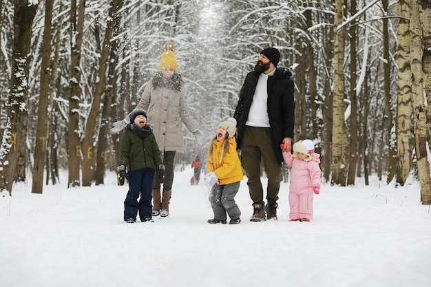 Gelukkige familie spelen en lachen in de winter buiten in de sneeuw. Stadspark winterdag.