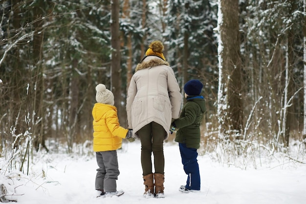 Gelukkige familie spelen en lachen in de winter buiten in de sneeuw. stadspark winterdag.