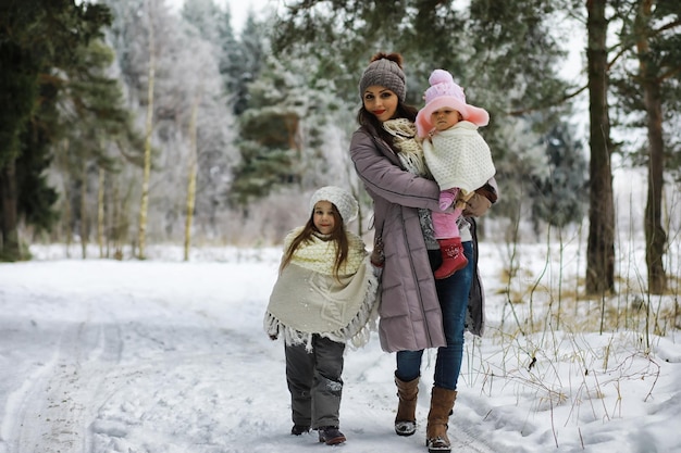 Foto gelukkige familie spelen en lachen in de winter buiten in de sneeuw stadspark winterdag