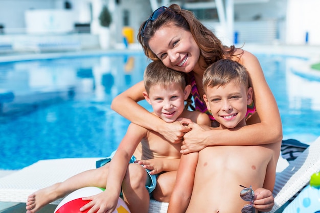 Gelukkige familie spelen in zwembad. Zomer vakantie concept