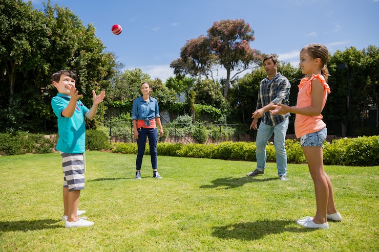 Foto gelukkige familie spelen met de bal in park