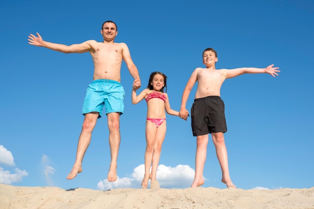 Gelukkige familie spelen op het zand poseren voor de camera Familie spelletjes op vakantie