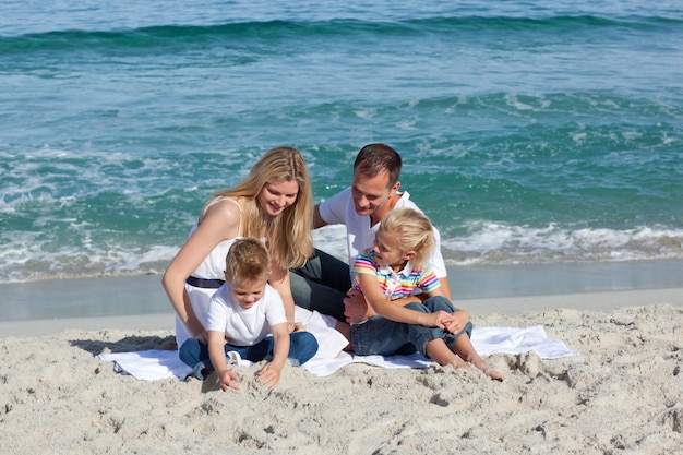 Gelukkige familie spelen op het zand