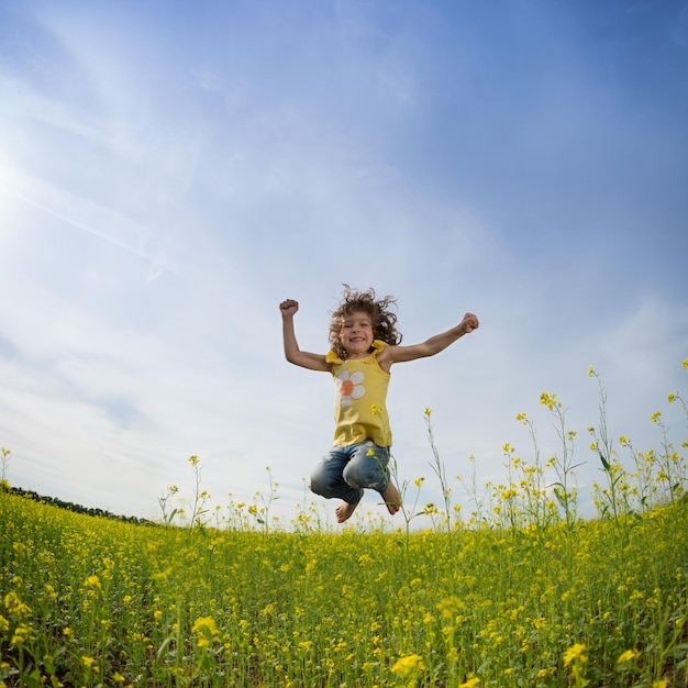 Gelukkige familie springen in groen veld tegen blauwe hemel Zomervakantie concept