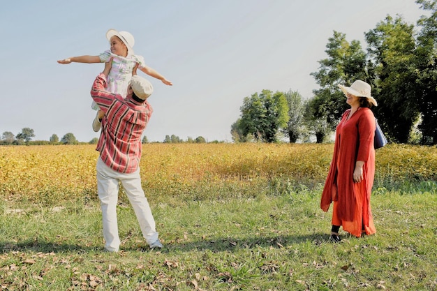 Gelukkige familie staat op het veld tegen de lucht
