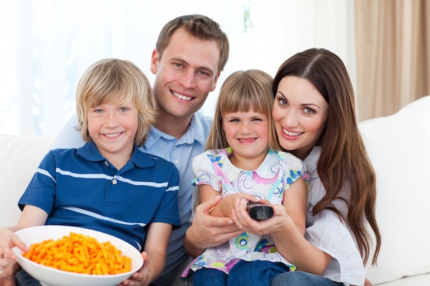 Gelukkige familie televisie kijken en chips eten