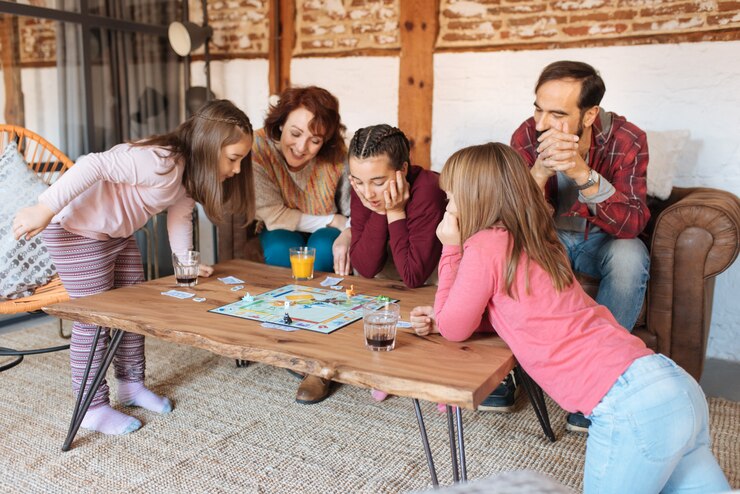 Gelukkige familie thuis in de bank klassieke tafelspelen spelen