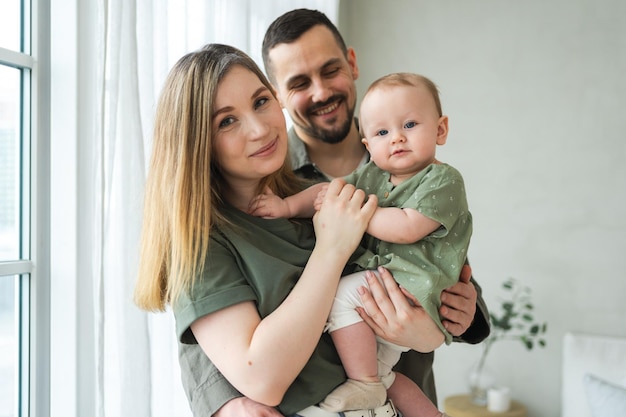 Foto gelukkige familie thuis moeder vader houdt kleine peuter kind moeder vader baby meisje ontspannen spelen