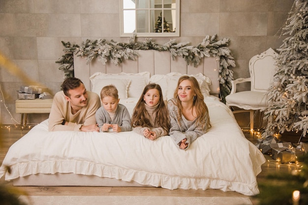 Foto gelukkige familie thuis op het bed nieuw jaarconcept