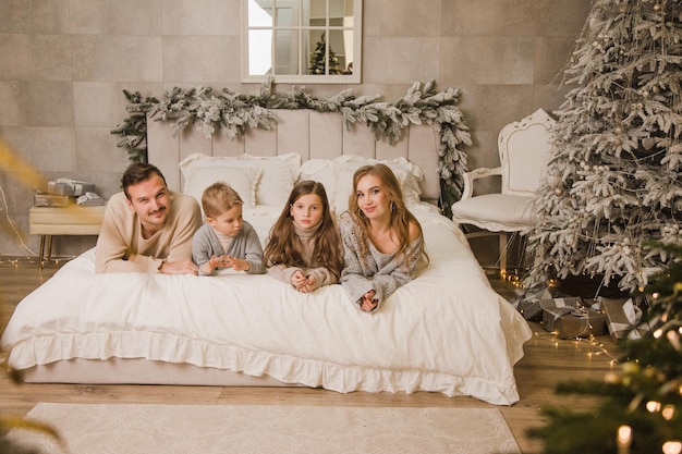 Foto gelukkige familie thuis op het bed nieuw jaarconcept