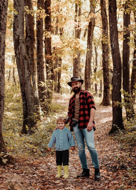 Gelukkige familie vader en zoontje spelen en lachen op herfstwandeling vader en zoon lopen tijdens t