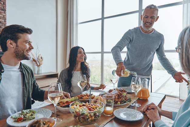 Gelukkige familie van meerdere generaties die communiceert en lacht terwijl ze samen eten