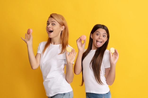 Gelukkige familie van moeder en kind houden franse macaronkoekjes, lekker.