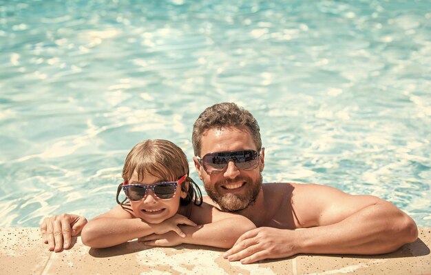 Gelukkige familie van vader en kleine jongen die plezier hebben in de zomerzwembadvakanties